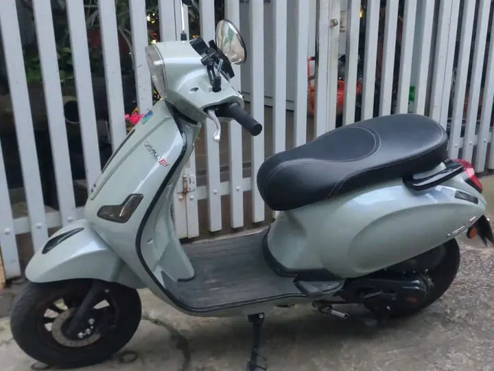 Pastel green 50cc scooter for rent in Dalat, parked by the white fence outside our shop