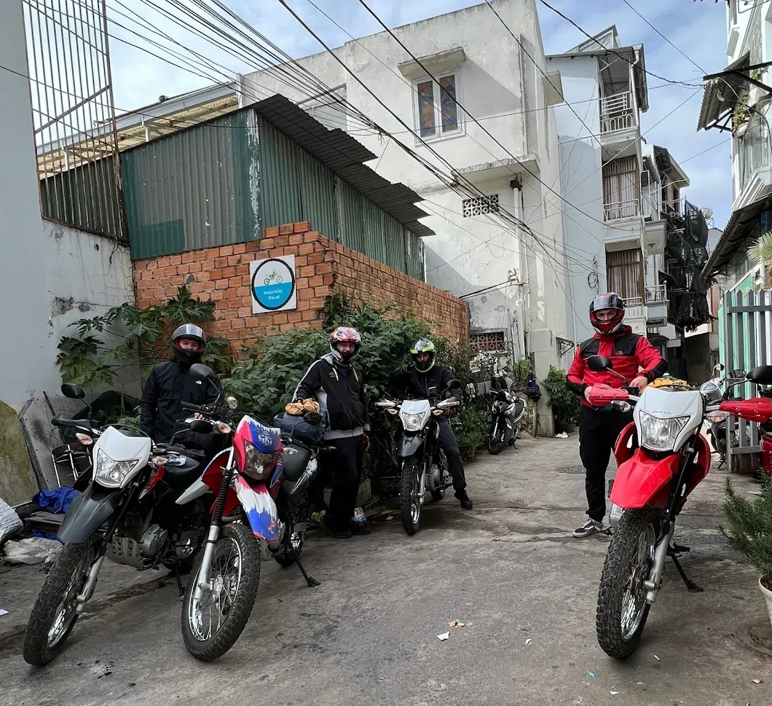 The Motorbike Dalat sign on the brick wall in the alley, with Honda XR150 bikes parked outside